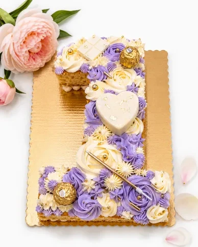Number 1 cake decorated with lavender and white buttercream and gold accents